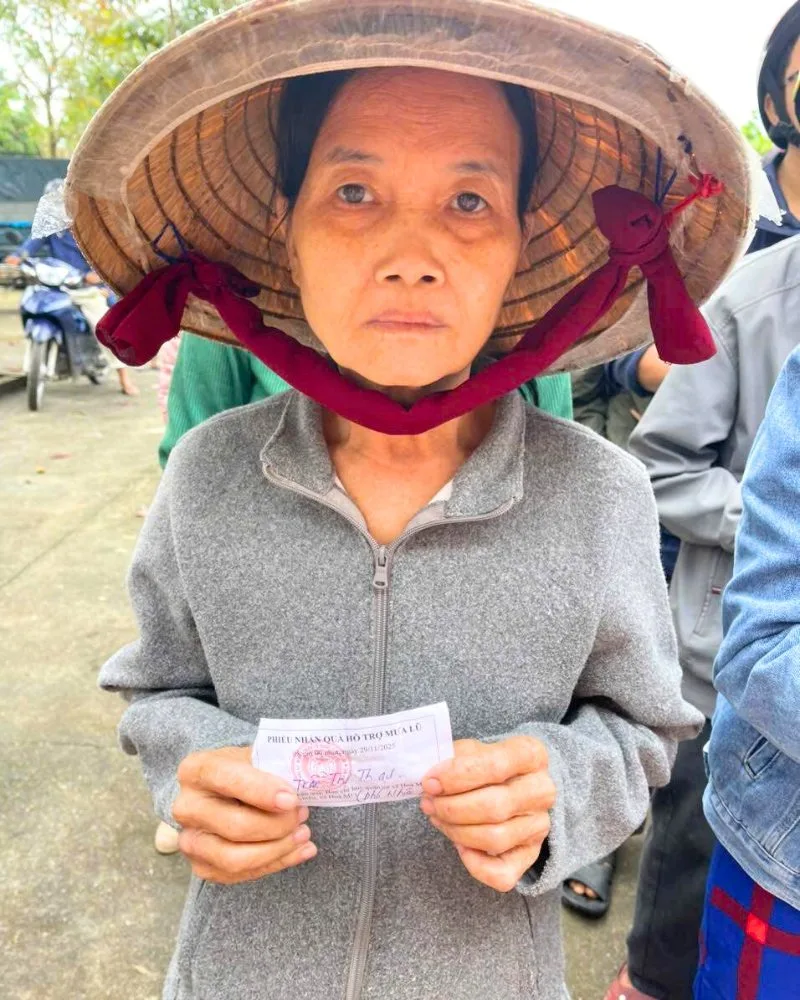 A disaster-affected resident holding her coupon to receive emergency aid